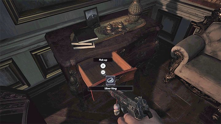 Schauen Sie in der Halle des Vergnügens in die Schreibtischschublade, um den Ring zu finden – Resident Evil Village: Silver Ring und Azure Eye – wie findet und kombiniert man sie?  - FAQ - Resident Evil Village Guide