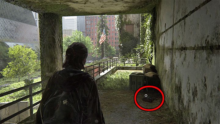 Reach the roof-covered balcony shown in the screenshot and check out the bag lying on the ground next to the crates - The Last of Us 2: Downtown map - collectibles, artefacts, coins - Seattle Day 1 - Ellie - The Last of Us 2 Guide